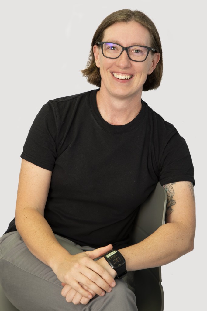 Image of Megan D'Arcy wearing glasses and smiling